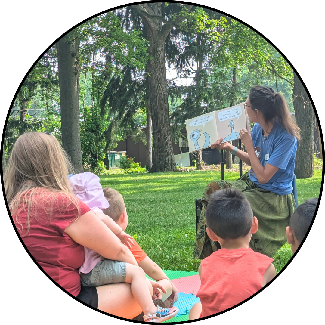 Librarian reading to kids and parents at outdoor story time